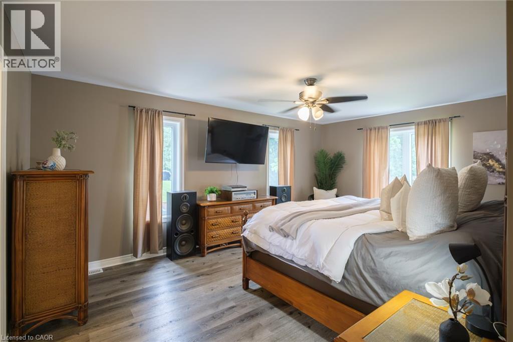 Wood-finish flooring, multiple windows providing natural illumination, and a ceiling fan with integrated lighting - 78 Oak Street, Simcoe, ON