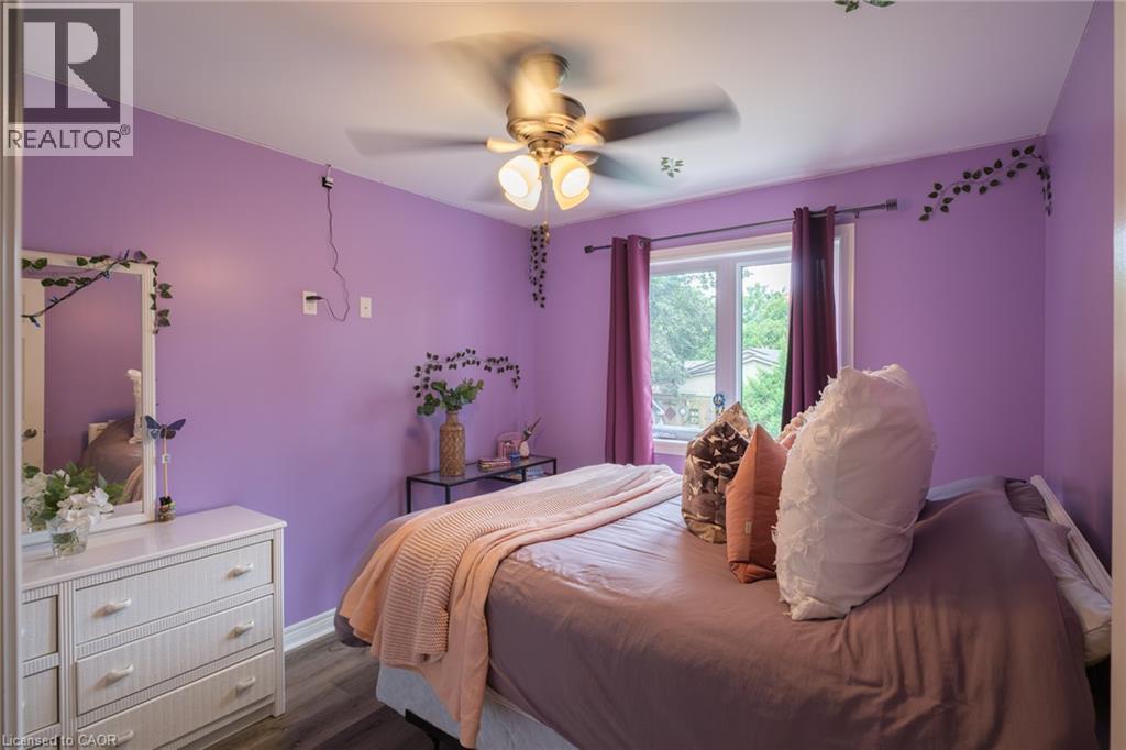 Recessed window with white trim, ceiling fan with light fixture, wood-finish flooring - 78 Oak Street, Simcoe, ON