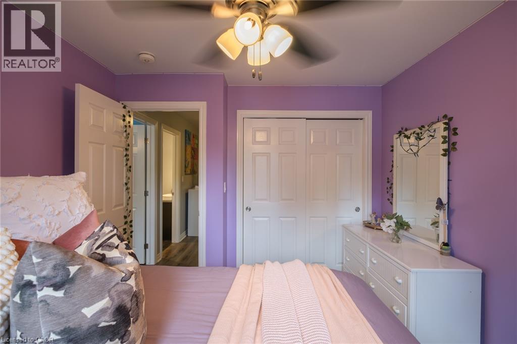Ceiling fan with integrated lighting, white interior doors, and sliding closet doors - 78 Oak Street, Simcoe, ON