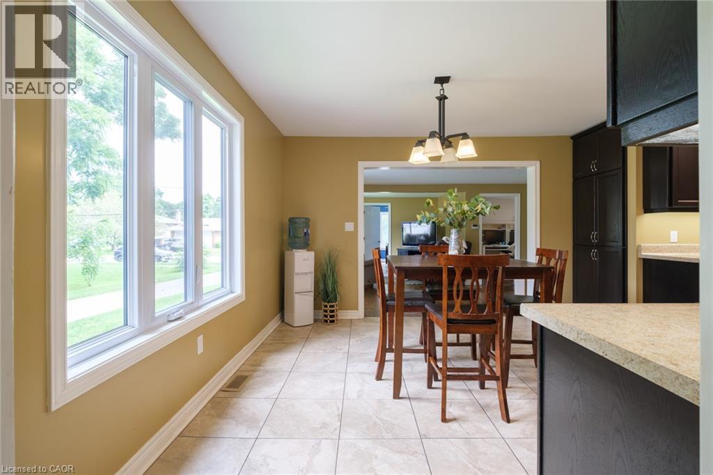 Tile flooring, multi-pane window, open doorway, dark wood-finish cabinetry, and light-toned countertops - 78 Oak Street, Simcoe, ON
