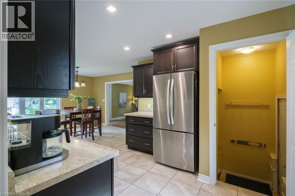 Tile flooring, dark wood-finish cabinetry, stainless steel refrigerator, recessed lighting, and a well-lit entryway - 78 Oak Street, Simcoe, ON