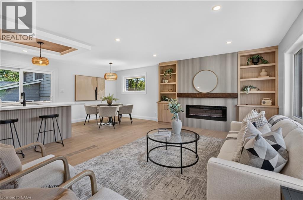 Open-concept living area featuring wood-finish flooring, recessed lighting, and a built-in fireplace with custom shelving - 3028 Eva Drive, Burlington, ON