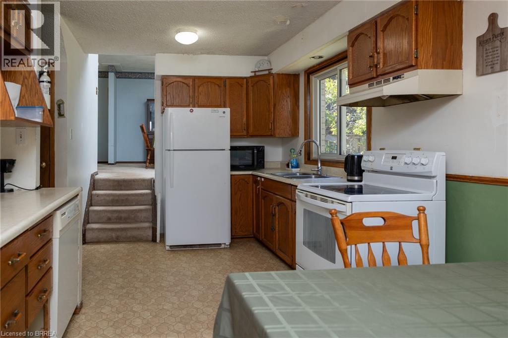 Kitchen featuring wood cabinetry and an electric range with an overhead hood - 52 Brier Park Road, Brantford, ON