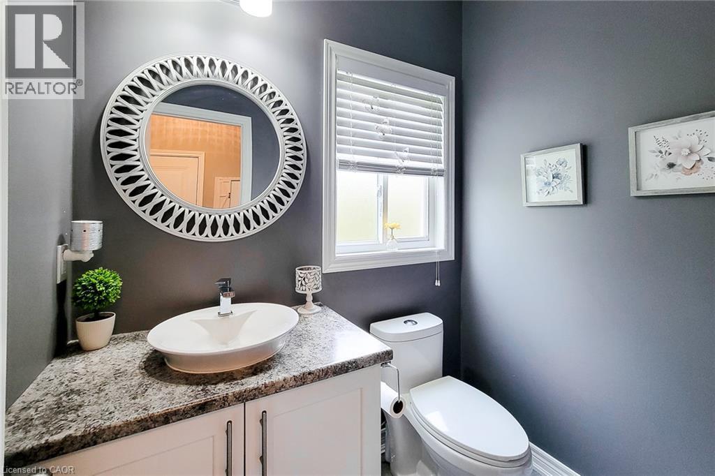 White vanity with cabinet storage, a vessel sink, and a speckled countertop - 4274 Sixth Avenue, Niagara Falls, ON
