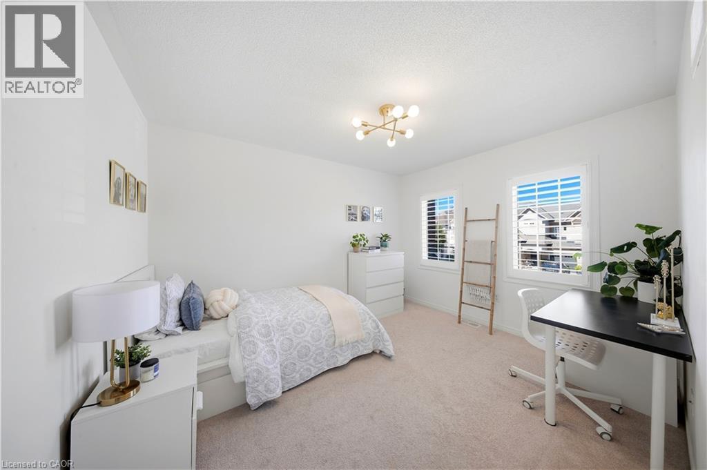 Recessed windows with plantation shutters, light-toned carpet flooring, and a modern ceiling light fixture - 3352 Hiscott Avenue, Burlington, ON