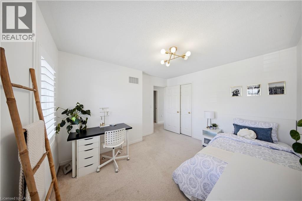 Neutral wall finishes, recessed window with white plantation shutters, soft carpet flooring, and a modern ceiling light fixture - 3352 Hiscott Avenue, Burlington, ON