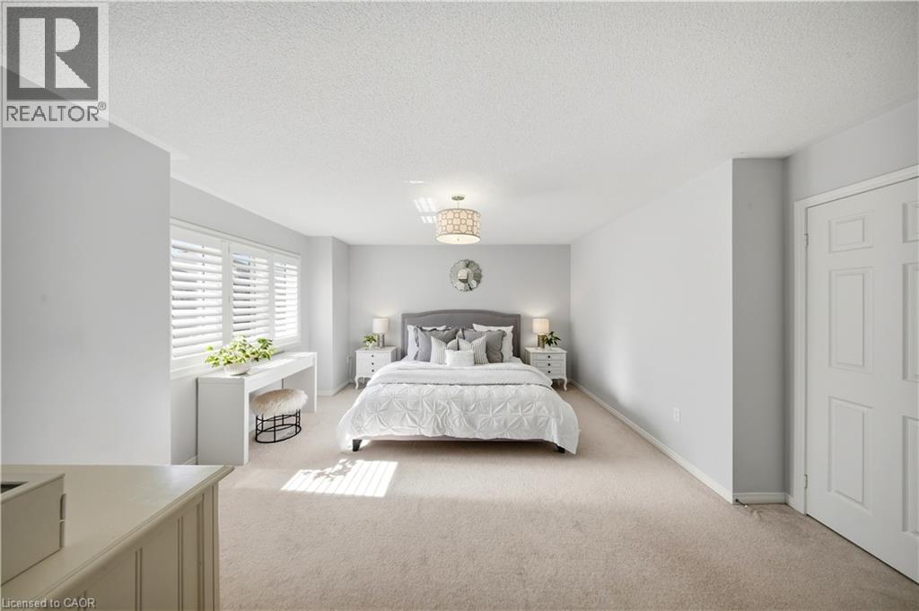 Carpeted bedroom with a built-in window desk, plantation shutters, and a central chandelier - 3352 Hiscott Avenue, Burlington, ON