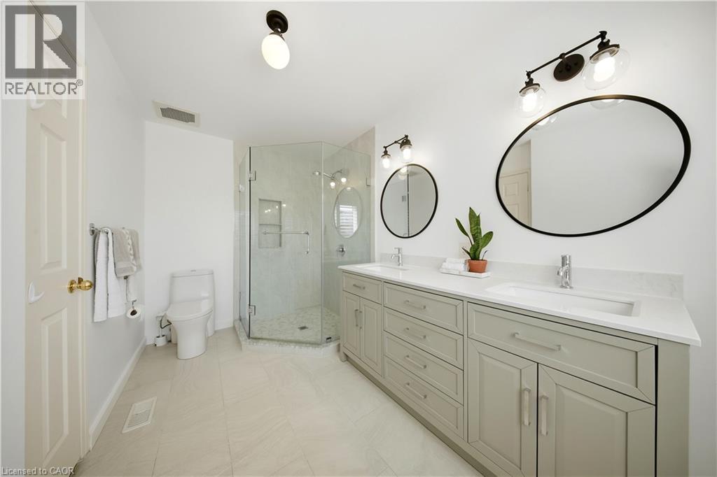 Dual vanity with quartz countertops, undermount sinks, and contemporary matte black-framed mirrors - 3352 Hiscott Avenue, Burlington, ON