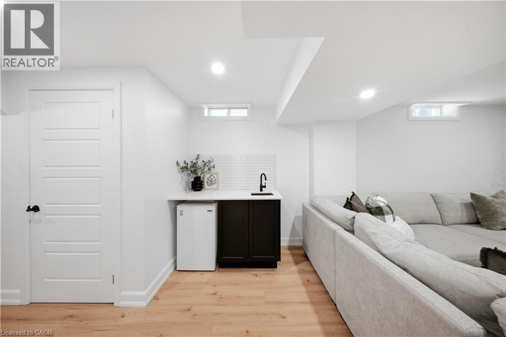 Wet bar featuring a dark cabinet, white countertop, and white subway tile backsplash - 3352 Hiscott Avenue, Burlington, ON