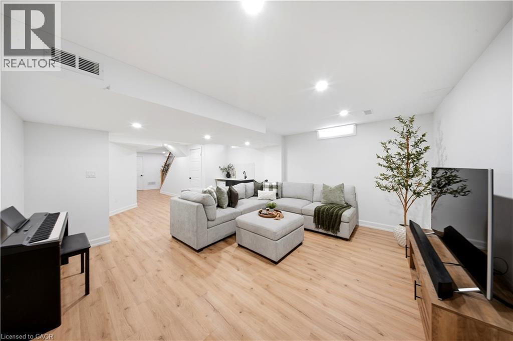 Open-concept living space featuring wood-finish flooring, recessed lighting, and white walls - 3352 Hiscott Avenue, Burlington, ON