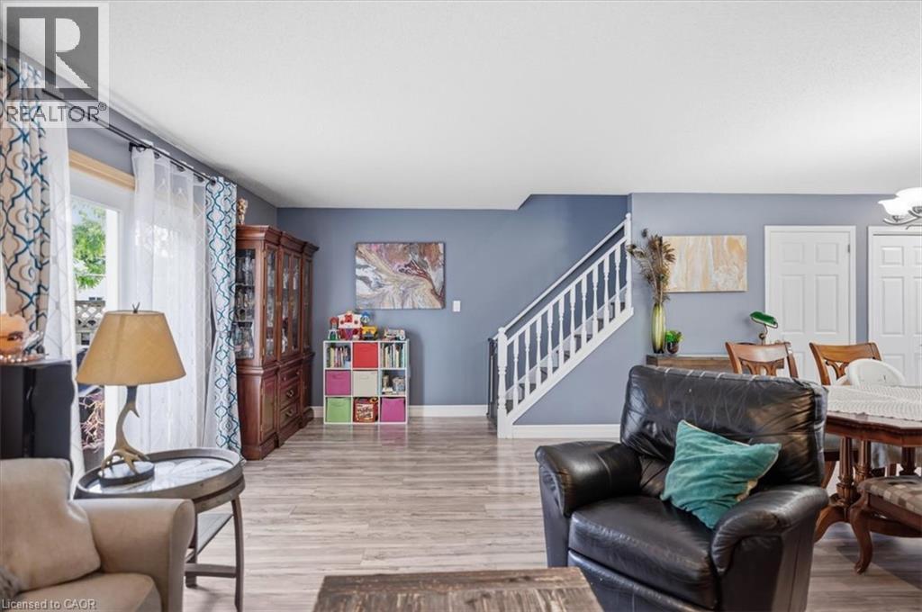 Wood-finish flooring throughout, white-painted staircase, and white interior doors - 4804 John Street, Beamsville, ON