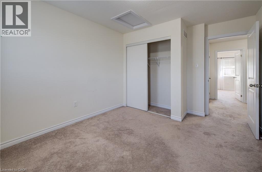 Neutral-toned wall-to-wall carpeting and off-white walls - 403 Westwood Drive Unit# 59, Kitchener, ON