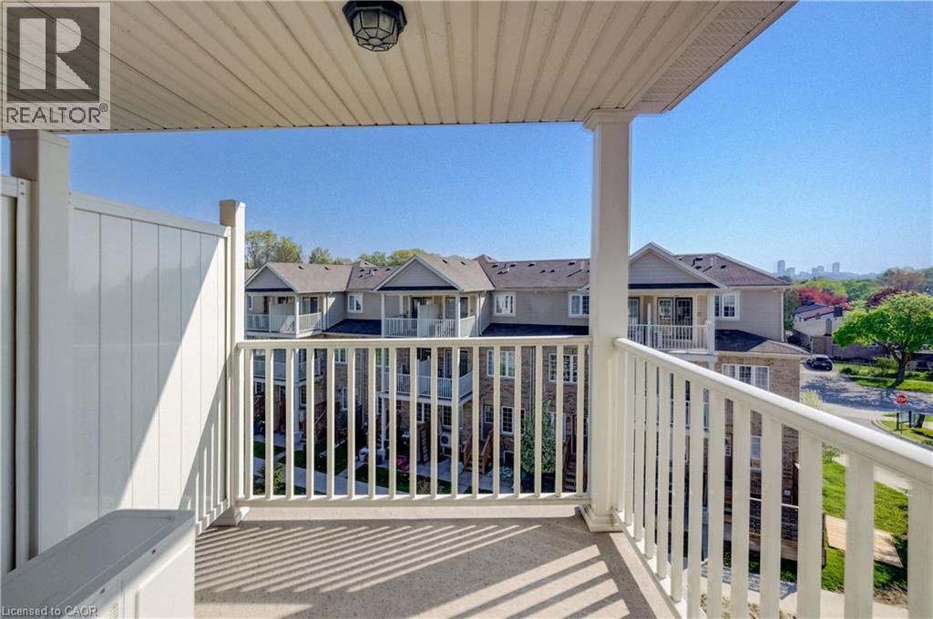 Private balcony featuring a concrete floor, white spindle railing, and a vinyl privacy wall - 403 Westwood Drive Unit# 59, Kitchener, ON