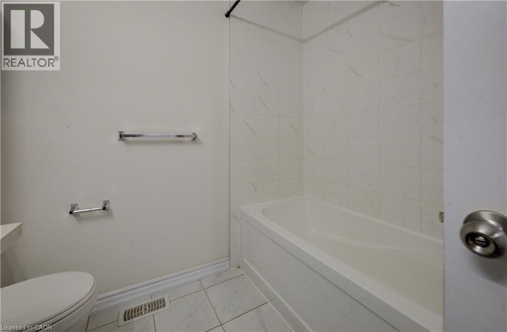 White porcelain bathtub with surrounding tile enclosure - 403 Westwood Drive Unit# 59, Kitchener, ON