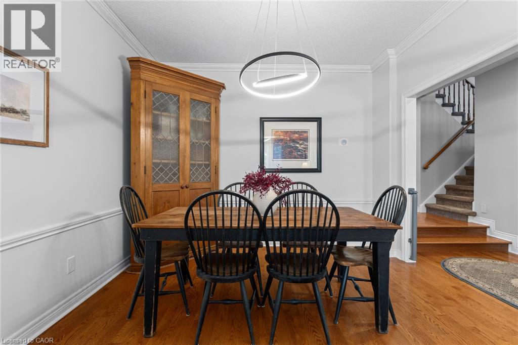 Hardwood flooring, crown molding, chair rail molding, modern linear pendant light fixture, and staircase with carpeted treads - 1610 Heathside Crescent, Pickering, ON