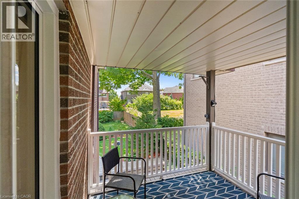 Covered balcony with a patterned area rug, white railing, and brick exterior - 1610 Heathside Crescent, Pickering, ON