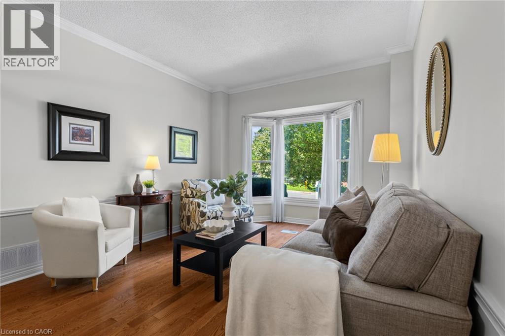 Bay window with multiple panes, crown molding, wood-finish flooring, and two-tone wall treatment - 1610 Heathside Crescent, Pickering, ON