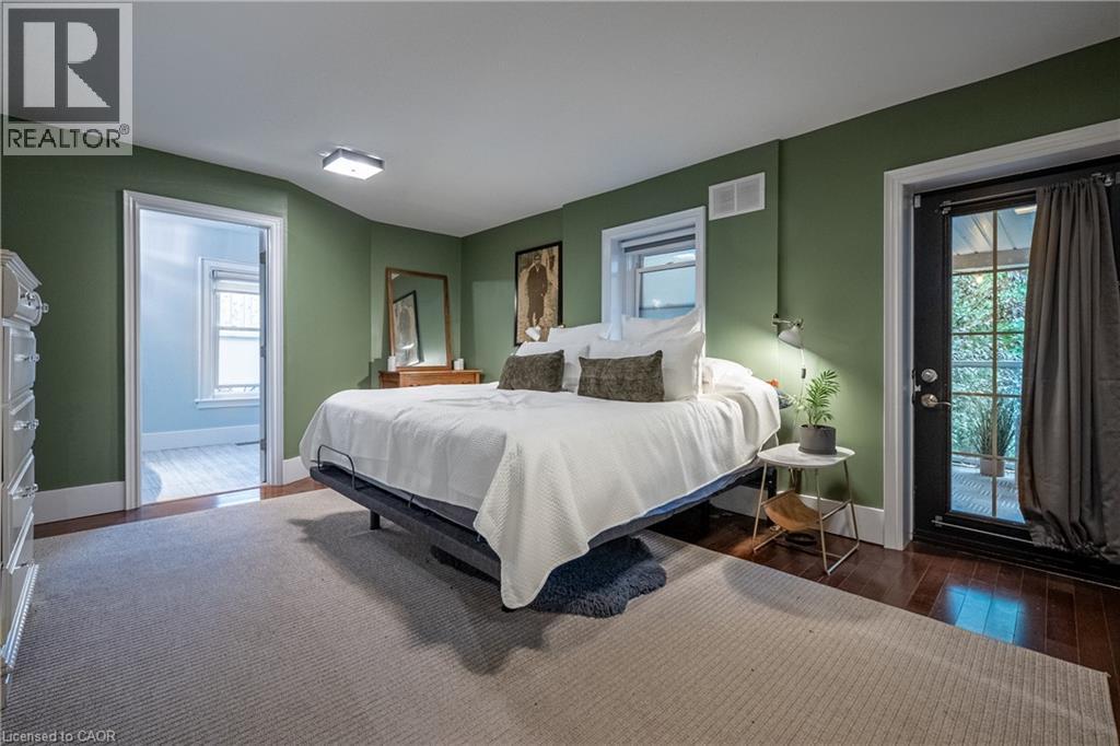 Hardwood flooring, wall-mounted sconce, and French door - 283 Plains Road W, Burlington, ON