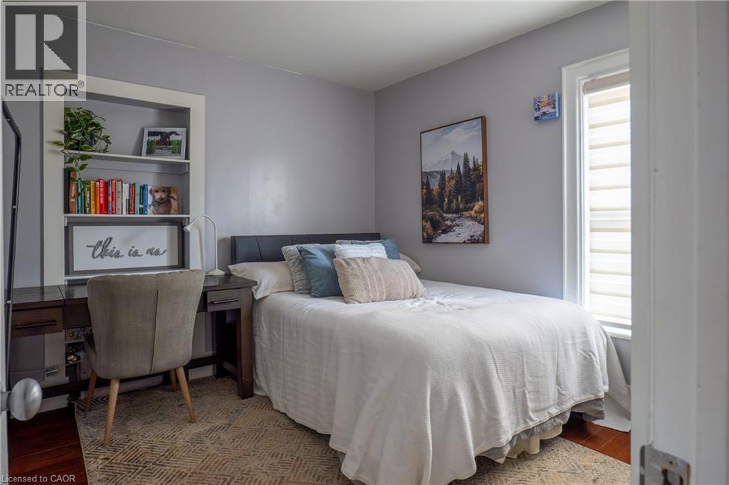 Recessed built-in shelving, wood-finish flooring, and a white-framed window with shades - 283 Plains Road W, Burlington, ON