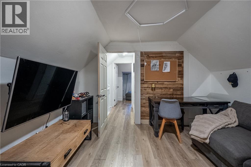 Sloped ceilings, wood-finish flooring, accent wall, paneled interior door, built-in shelving - 283 Plains Road W, Burlington, ON