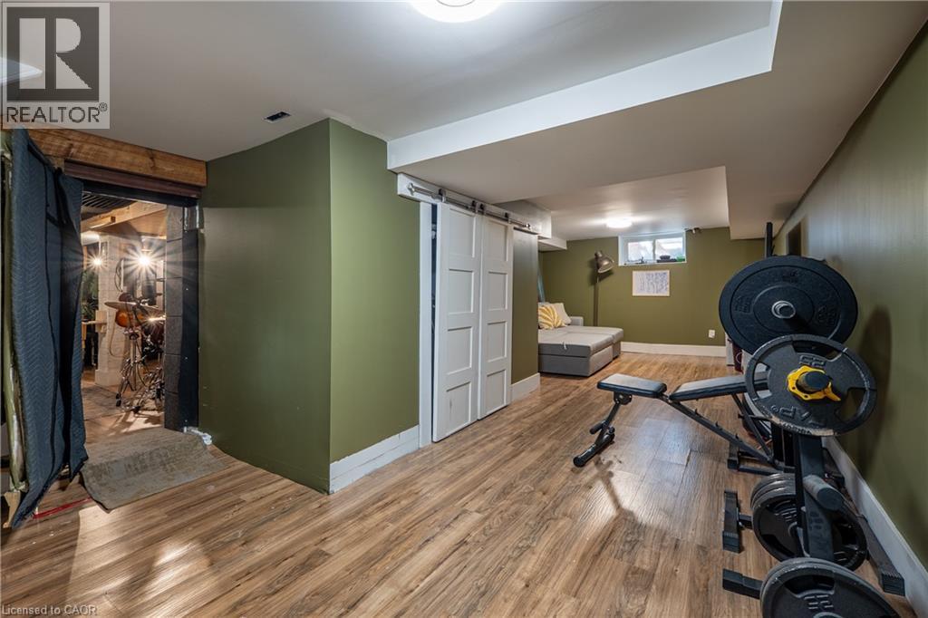 Wood-finish flooring, white barn door, and recessed lighting - 283 Plains Road W, Burlington, ON