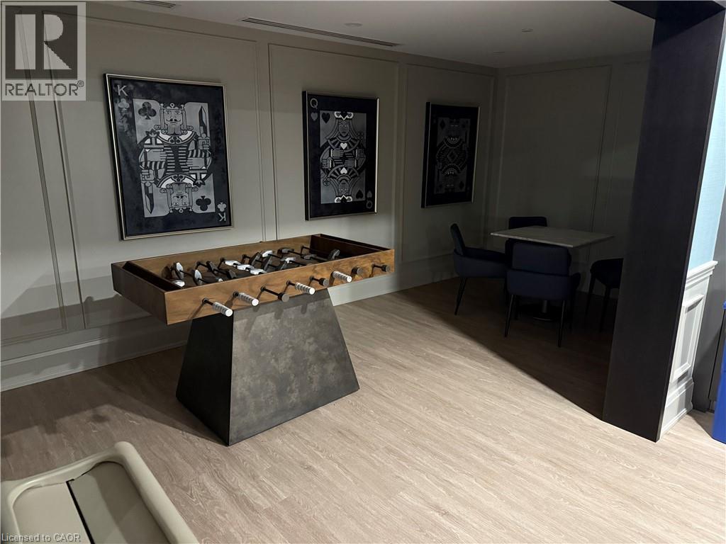 Wood-finish flooring throughout, white paneled accent walls, recessed lighting, and a built-in trim feature wall - 10 Mallard Trail Unit# 237, Waterdown, ON