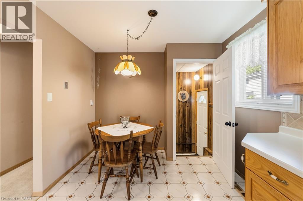 Kitchenette featuring patterned tile flooring, a wall-mounted light fixture, and a window with blinds - 450 Brigadoon Drive, Hamilton, ON