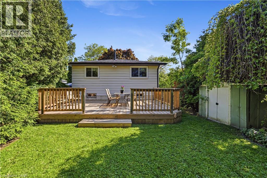 Expansive green lawn with newer, full sized wood deck, surrounded by mature trees and natural landscaping. Original shed. - 450 Brigadoon Drive, Hamilton, ON