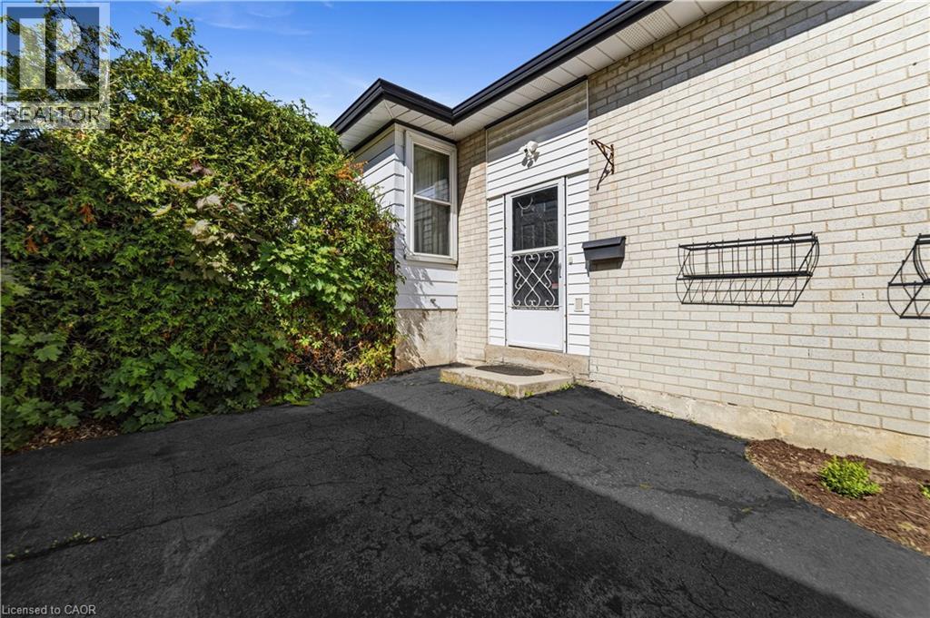 Main entry to the home, second entry on opposite side of the home. Paved driveway easily fits 2 cars. - 450 Brigadoon Drive, Hamilton, ON