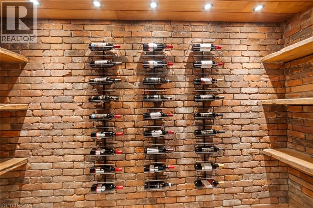 Wine room featuring brick wall, built in rustic shelving and recessed lighting on dimmer switch - 515 Hamilton Drive, Ancaster, ON