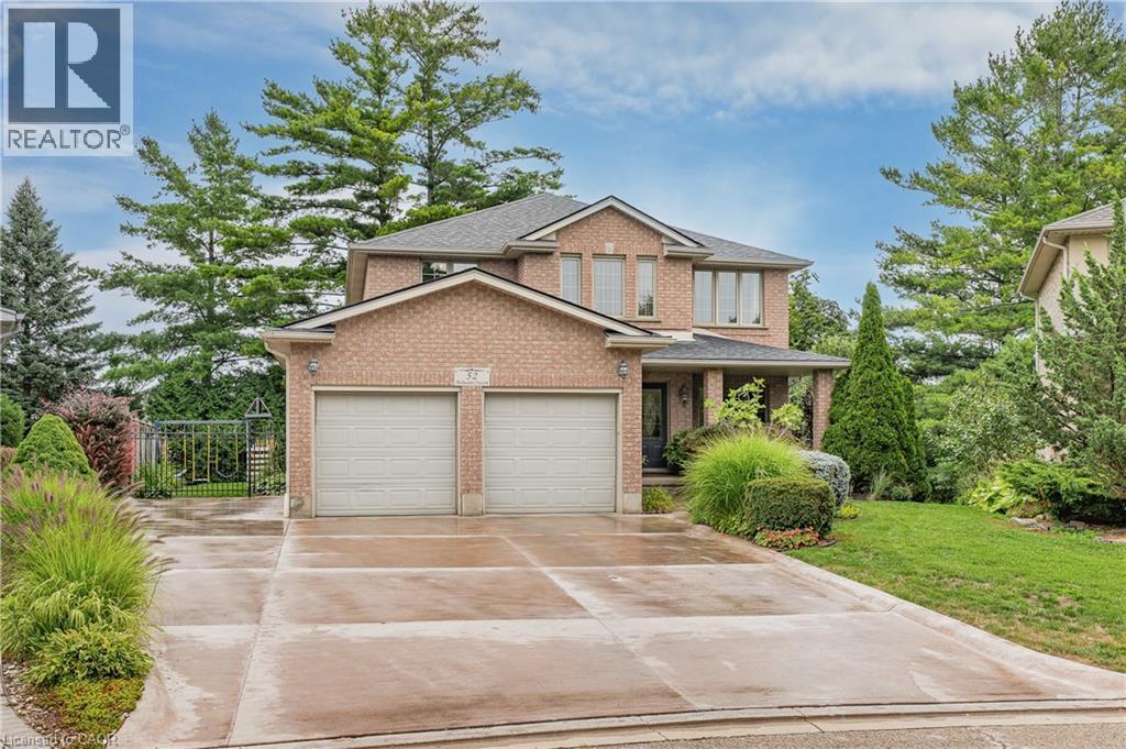 Brick exterior residence with a two-car garage, covered entry, and concrete driveway - 52 Archwood Crescent, Cambridge, ON