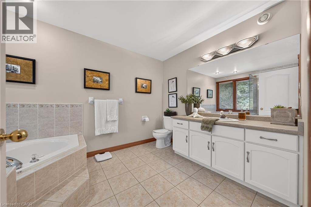 Expansive vanity with double sinks, white cabinetry, and a large mirror - 52 Archwood Crescent, Cambridge, ON