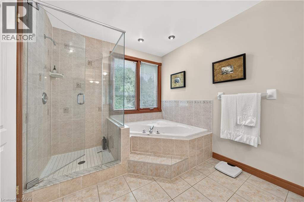 Walk-in glass-enclosed shower with tile surround, corner-set soaking tub, and tile flooring - 52 Archwood Crescent, Cambridge, ON