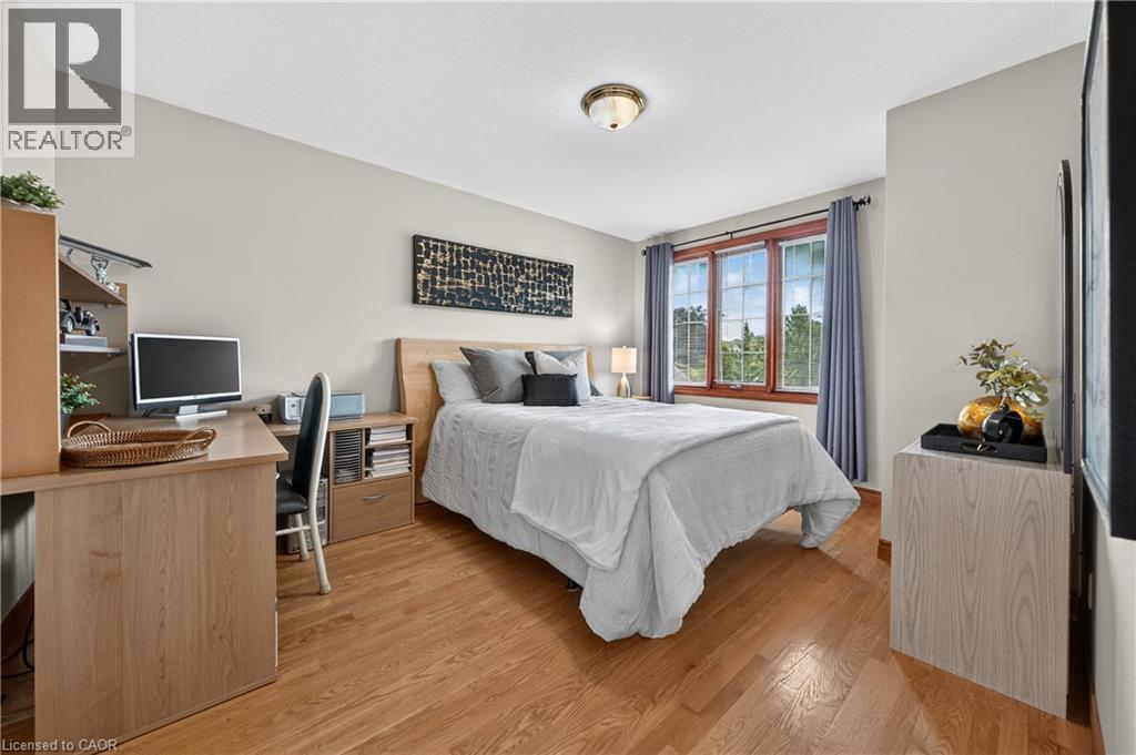 Hardwood flooring, neutral wall tones, three-panel window, flush mount ceiling fixture, and built-in desk with shelving - 52 Archwood Crescent, Cambridge, ON