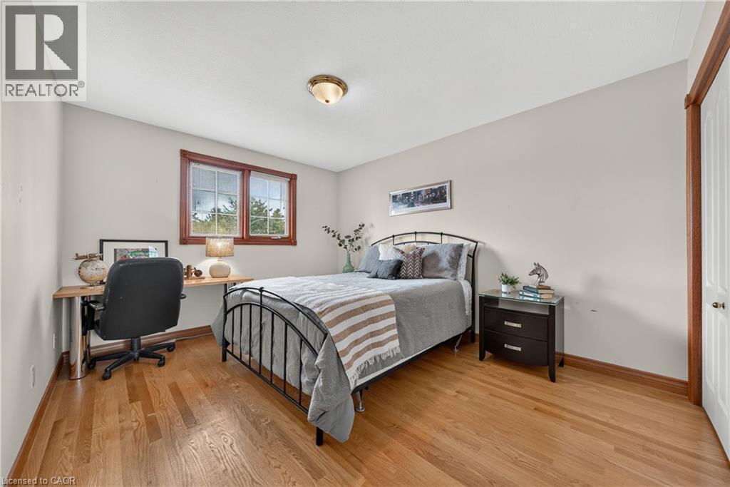 Hardwood flooring, light neutral wall paint, wood-framed window, flush mount ceiling light, and a white paneled door - 52 Archwood Crescent, Cambridge, ON