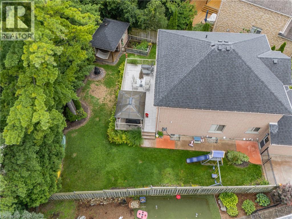Expansive backyard featuring a manicured lawn, established trees, and a multi-level deck with a gazebo - 52 Archwood Crescent, Cambridge, ON