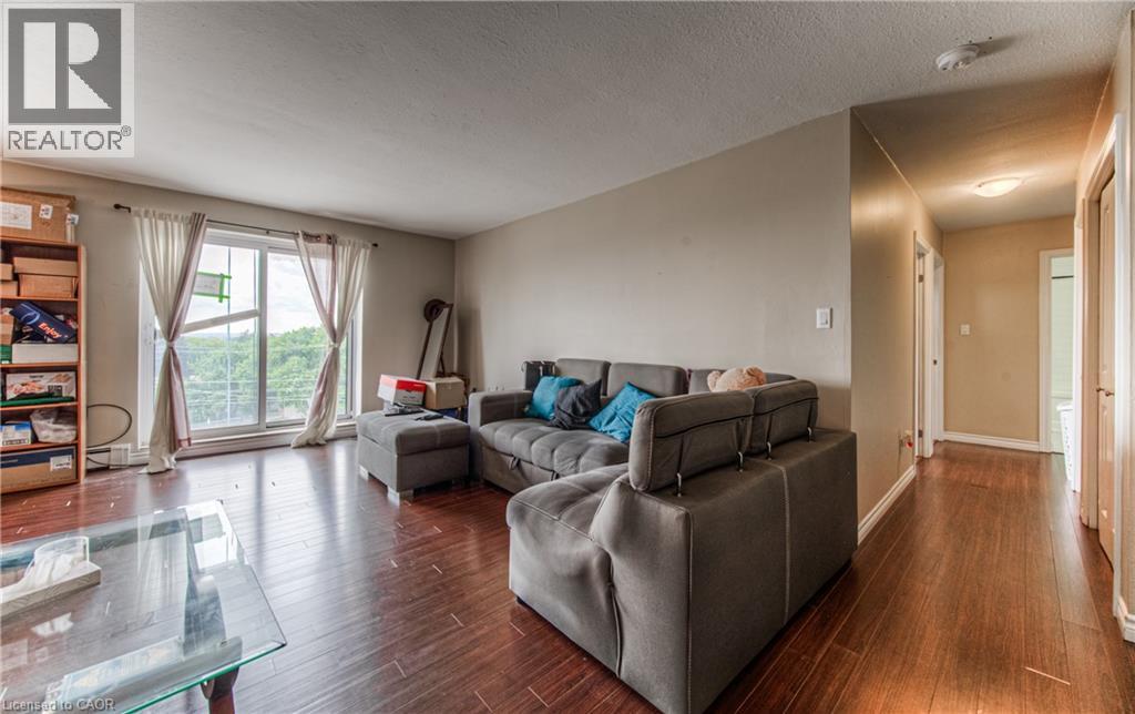Living area featuring dark wood-style floors and a textured ceiling - 283 Fairway Road N Unit# 501, Kitchener, ON