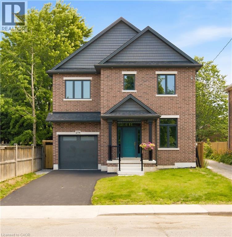 Brick exterior with a dark shingle roof and contrasting dark grey siding accents - 279 Hess Street S, Hamilton, ON