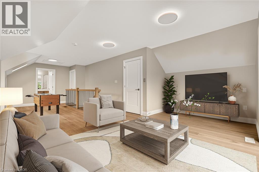 Vaulted ceiling with recessed lighting, wood-finish flooring, white panel doors, and a wood railing - 279 Hess Street S, Hamilton, ON