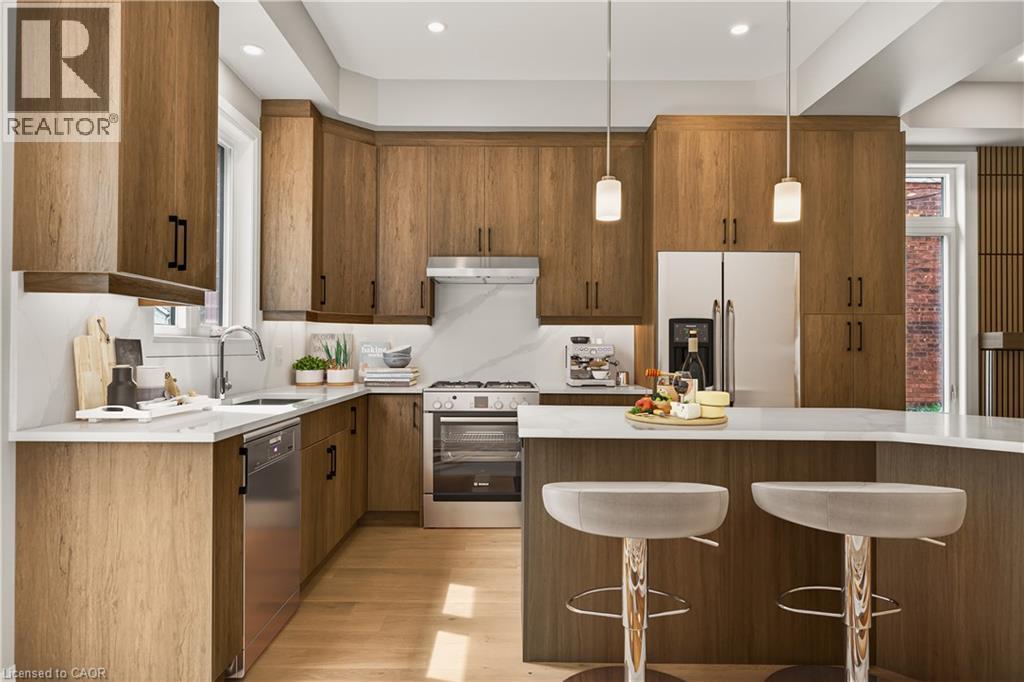 Wood-finish cabinetry, stainless steel appliances, a white countertop, and recessed lighting - 279 Hess Street S, Hamilton, ON