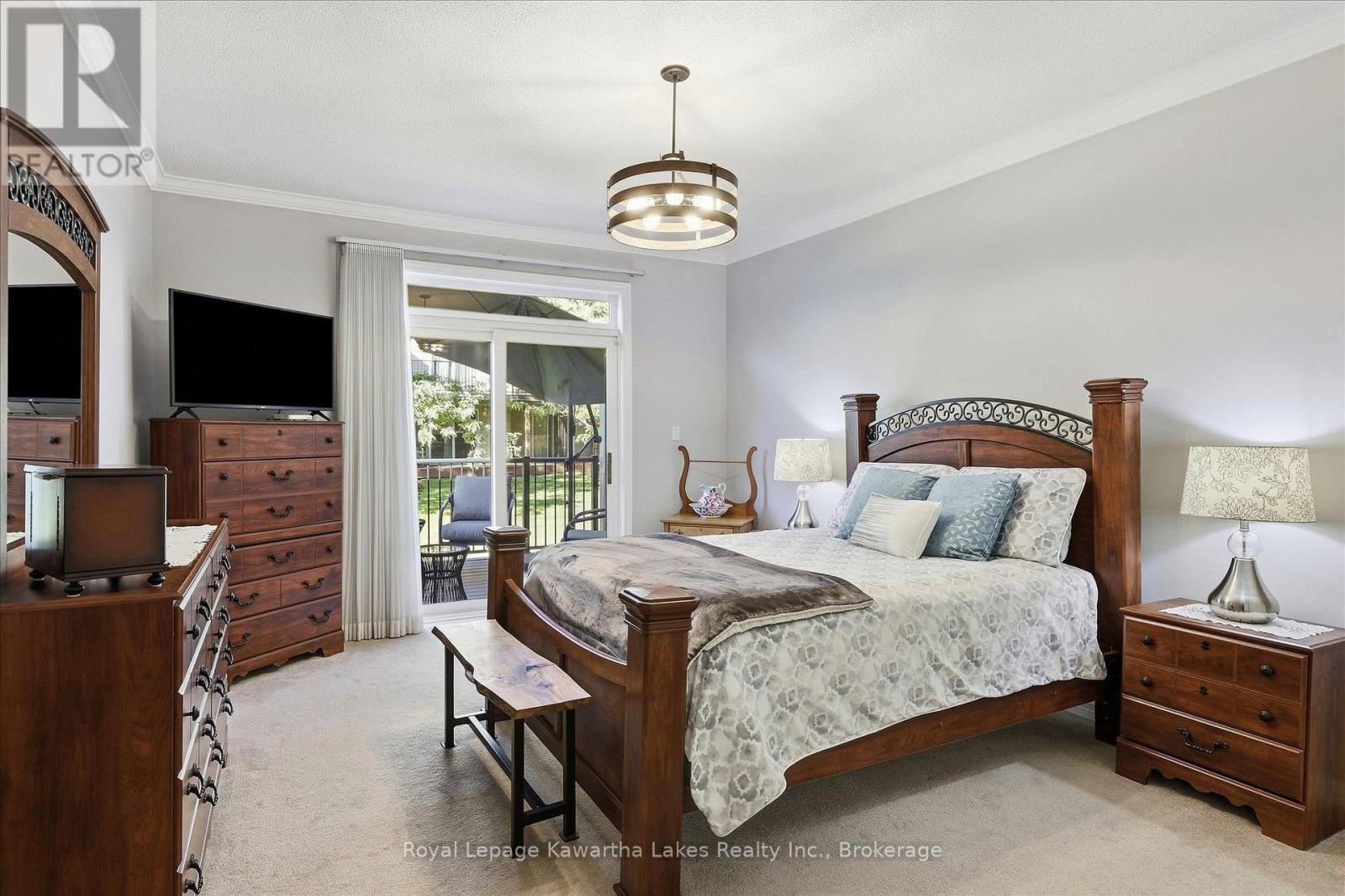 Primary bedroom with sliding doors to deck. - 10G - 25 Rivermill Boulevard, Kawartha Lakes (Lindsay), ON