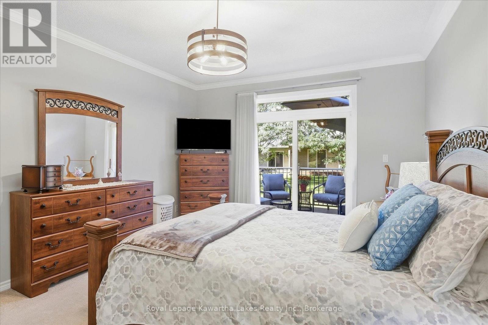 Large primary bedroom with crown moulding. - 10G - 25 Rivermill Boulevard, Kawartha Lakes (Lindsay), ON