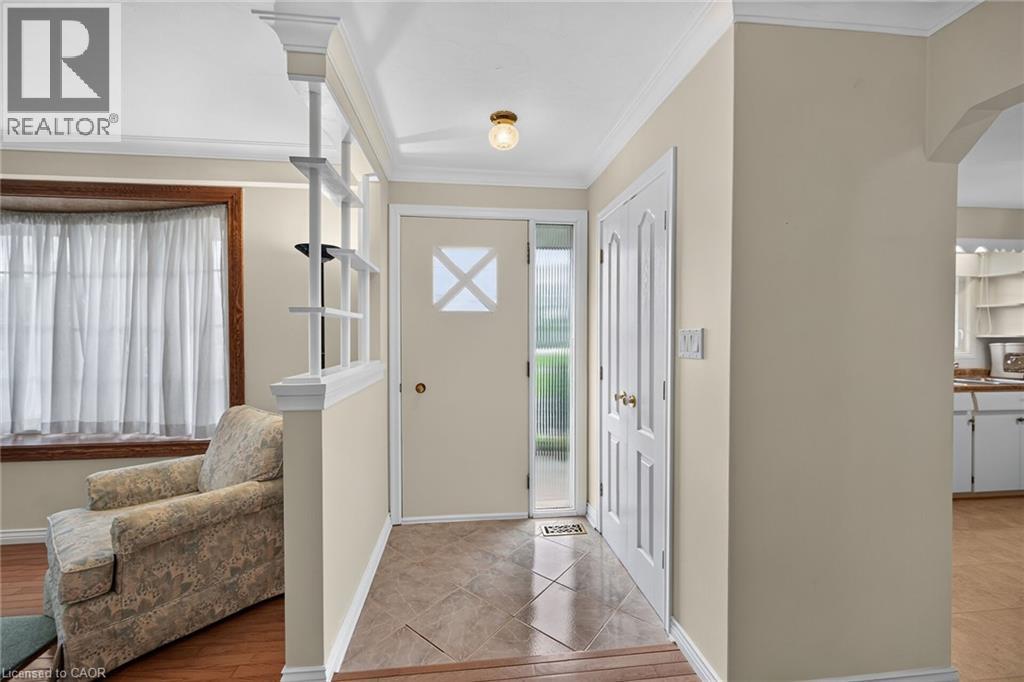 Entryway featuring tiled flooring, a single paneled door with frosted glass insert, and a double bi-fold door - 799 Highway 6, Caledonia, ON