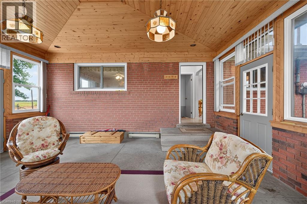Enclosed porch featuring exposed brick walls, wood-finish ceiling, and multiple windows - 799 Highway 6, Caledonia, ON