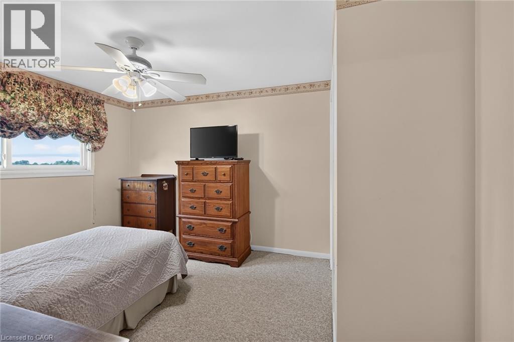 Carpeted flooring, a window with a valance, and a ceiling fan with integrated lighting - 799 Highway 6, Caledonia, ON