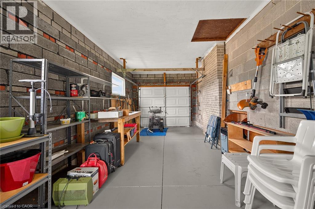 Interior block wall construction, concrete flooring, overhead garage door, and built-in shelving - 799 Highway 6, Caledonia, ON