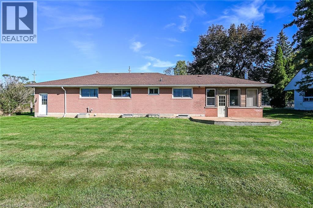 Brick exterior with multiple windows, leading to a rear deck - 799 Highway 6, Caledonia, ON