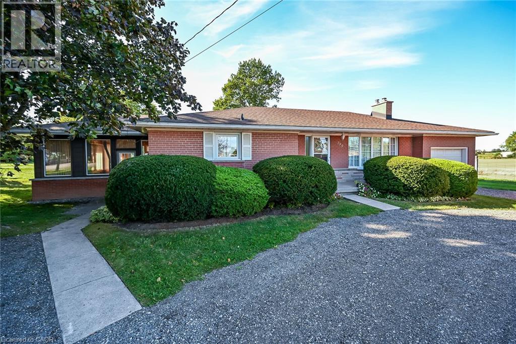 Brick exterior with white window shutters and a concrete walkway - 799 Highway 6, Caledonia, ON