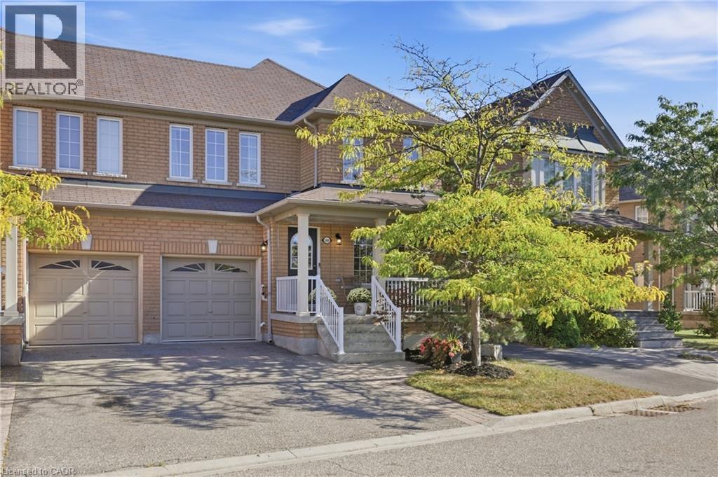 Brick exterior, multiple windows, two-car garage, covered porch with columns, paved driveway - 2409 Postmaster Drive, Oakville, ON