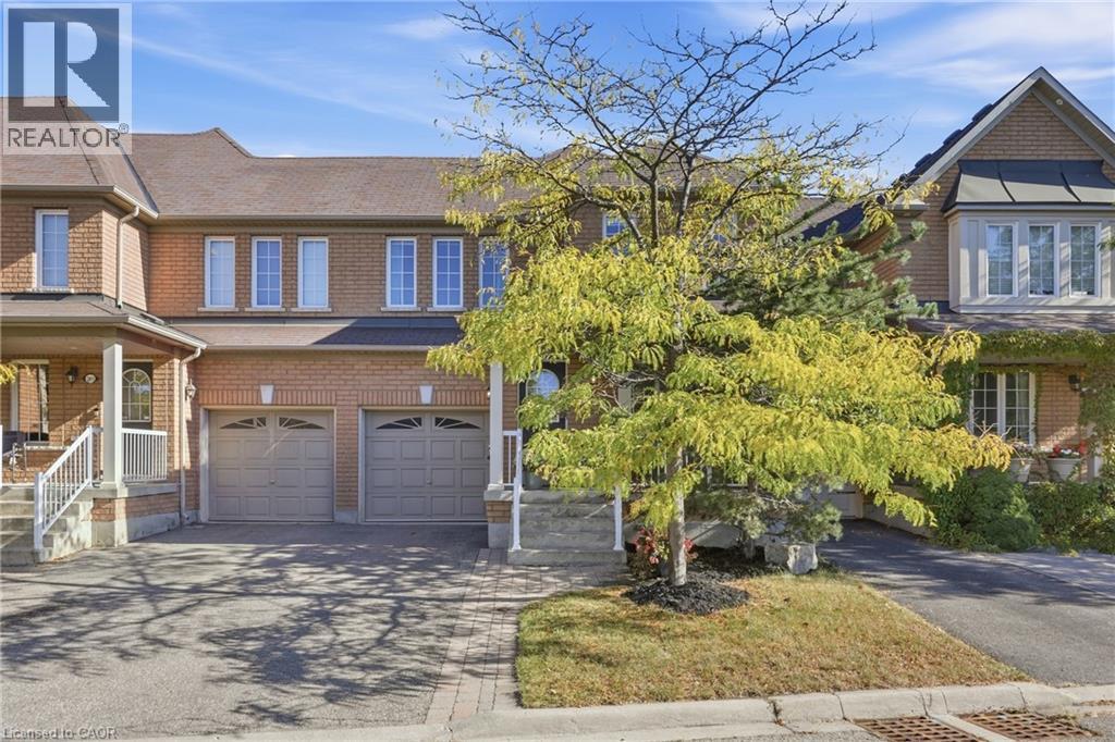 Brick exterior with multiple windows, attached two-car garage, and established front landscaping - 2409 Postmaster Drive, Oakville, ON